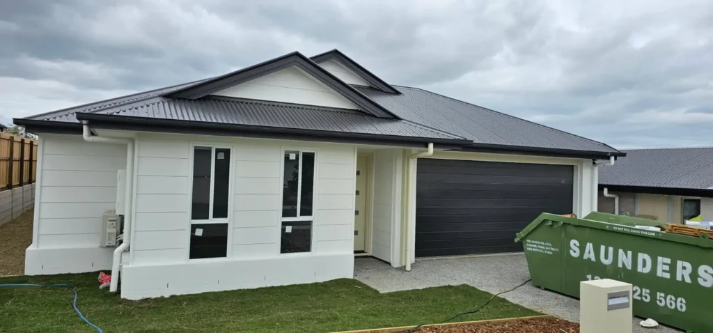 Newly painted single-storey home with white cladding and render