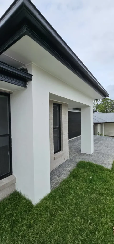 Freshly painted white rendered walls and eaves at a home entry