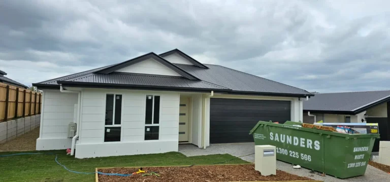 Front of a newly painted home with white render and dark roof