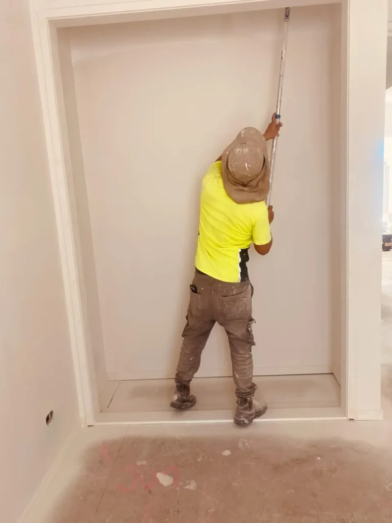 Austa Painting team member rolling paint onto an interior wall