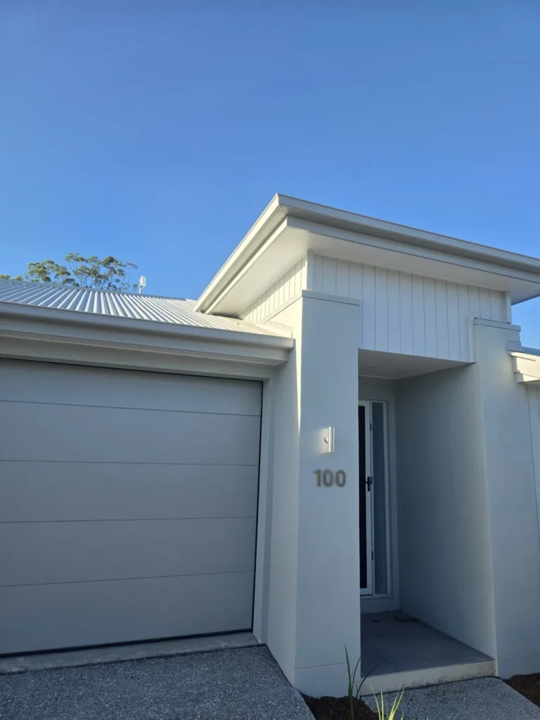New home entry with freshly painted white cladding, render and trims